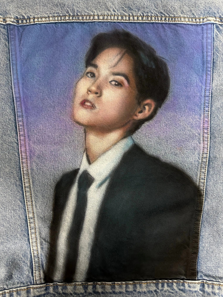 Close-up detail of hand-painted Woosung portrait on denim jacket